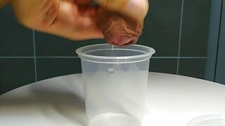 Milking small little cock for collecting milky cum to a cup